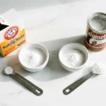 Baking soda and baking powder side by side with measuring spoons showing the different use rates per cup of flour